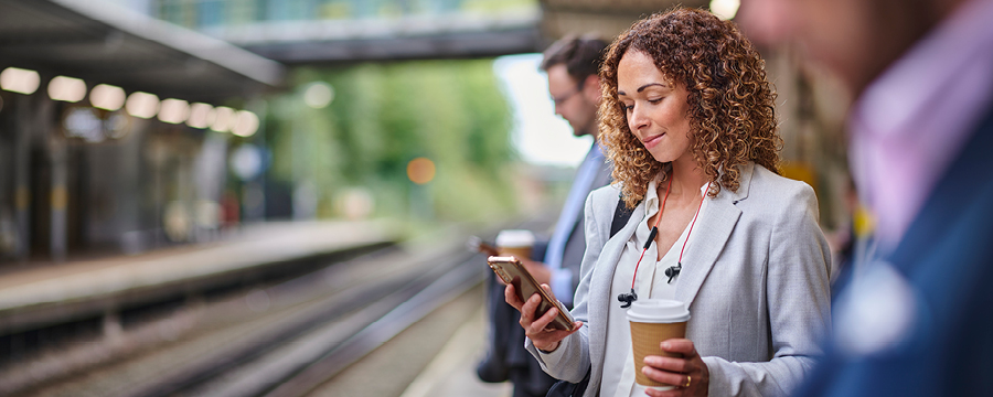 Woman texting while waiting for train.