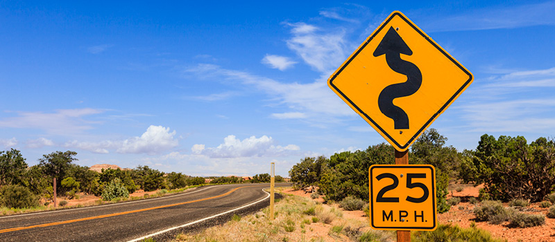 A winding road caution sign along a U.S. highway