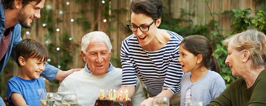 Mature man celebrating his birthday surrounded by family and friends.