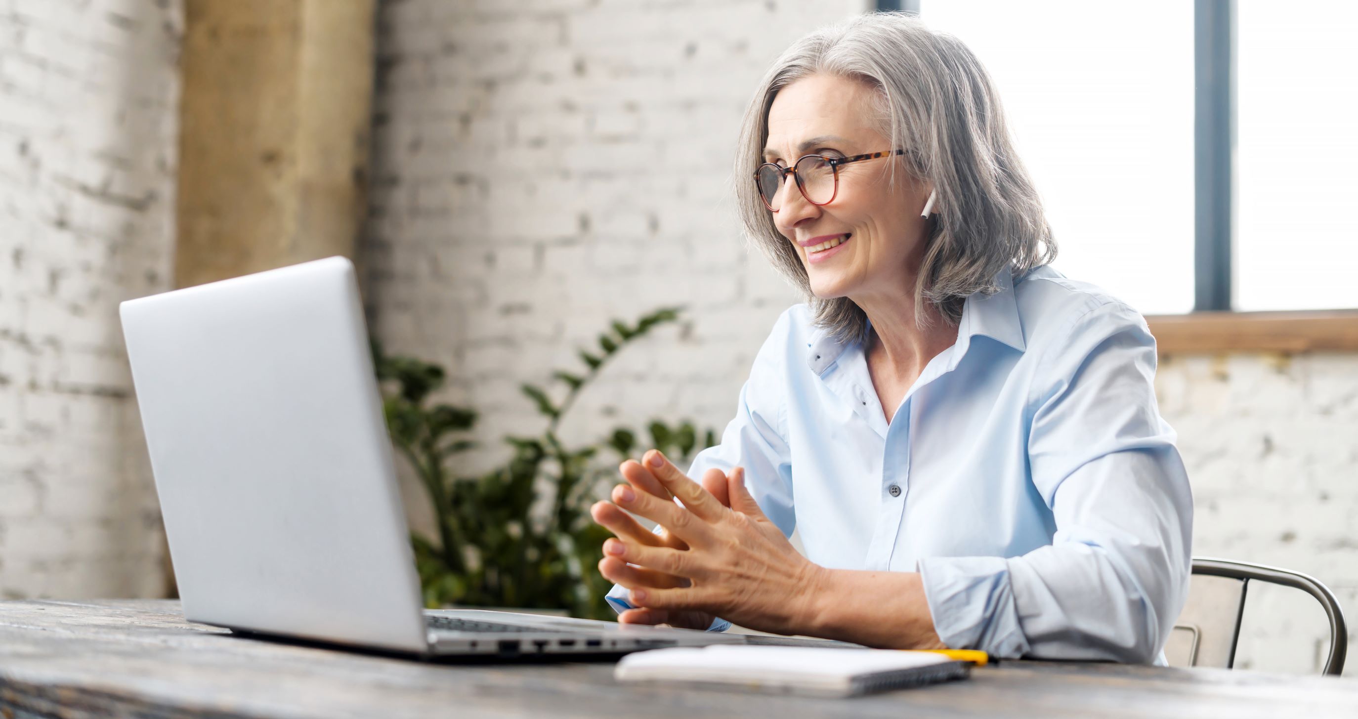 Woman with headphones smiling at computer