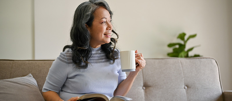 Happy woman drinking coffee, looking out window