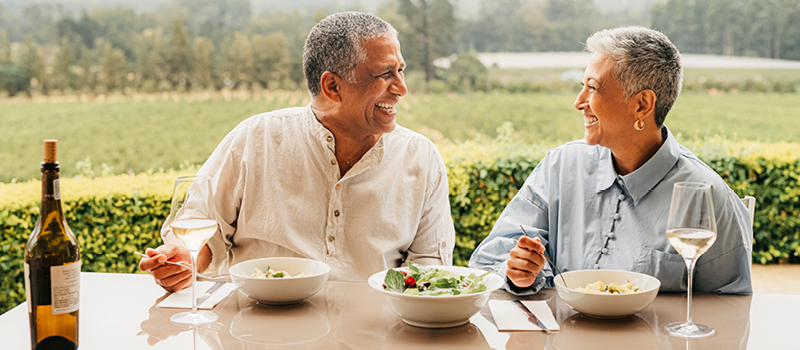 Mature couple eating lunch while on holiday at a vineyard.