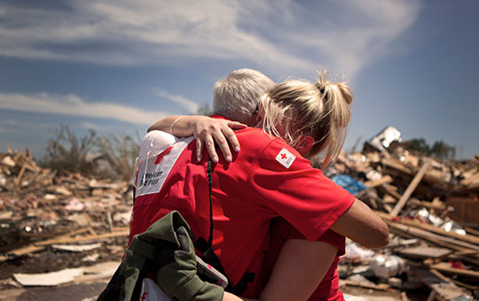 American Red Cross Disaster Relief volunteer embracing a community member